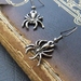 Dark Spider earrings: shiny dark-grey spider charms on gunmetal black hooks